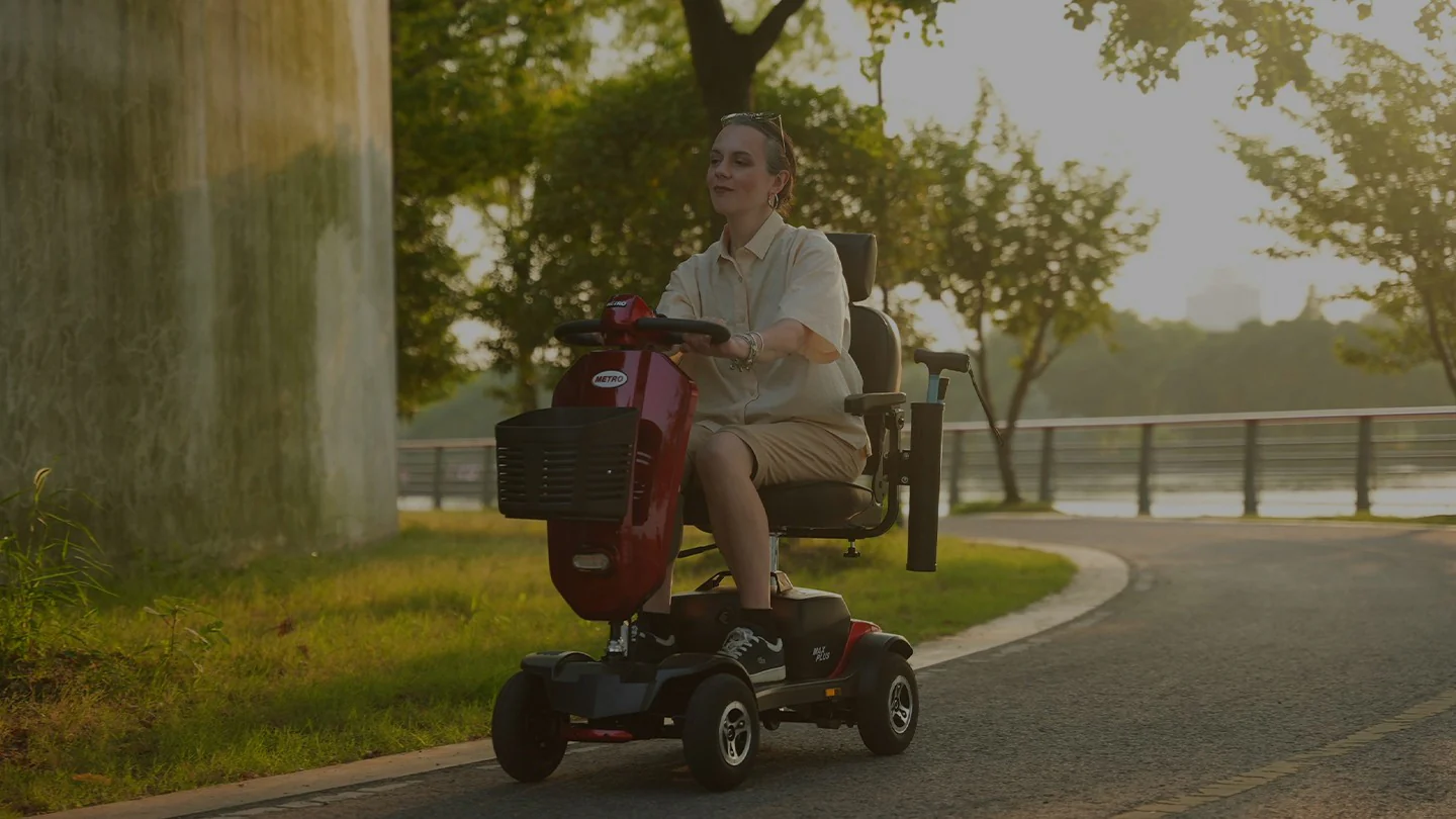 Woman riding red mobility scooter by lakeside