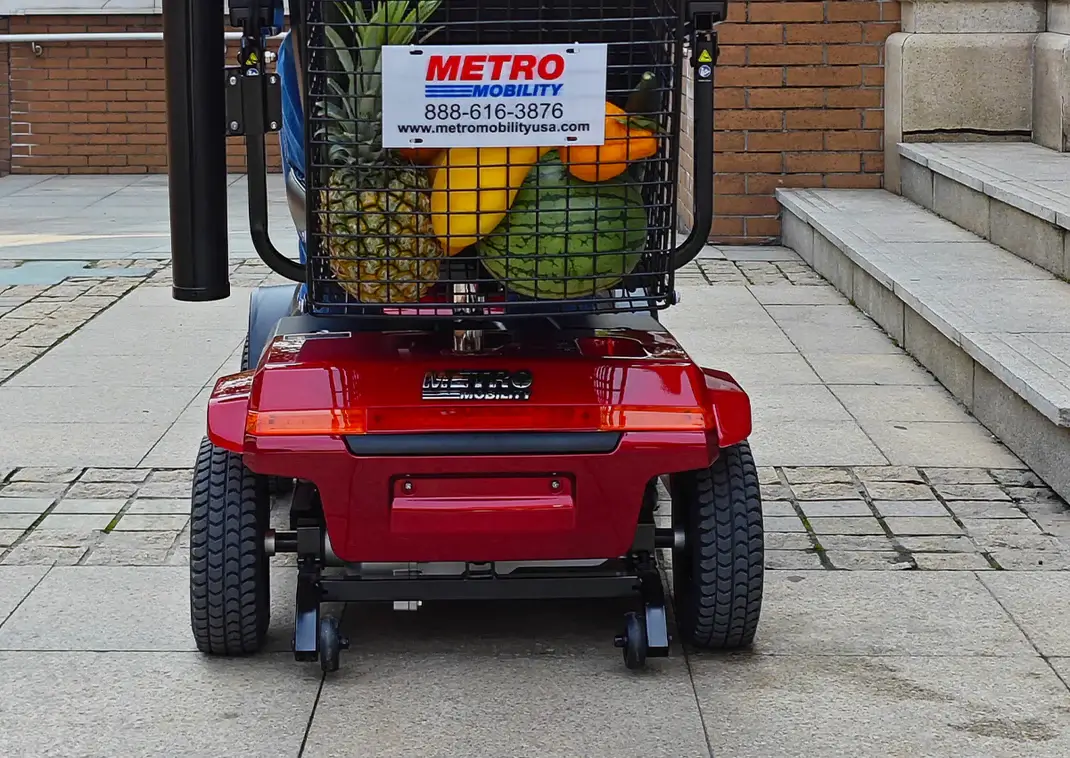 Red mobility scooter with a basket holding pineapples.