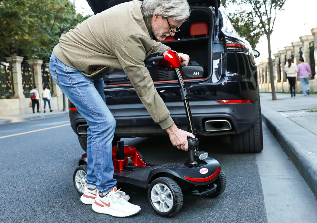 Man using a device to lift a small vehicle near a car.