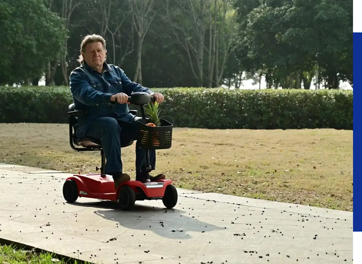 Man riding red mobility scooter in park