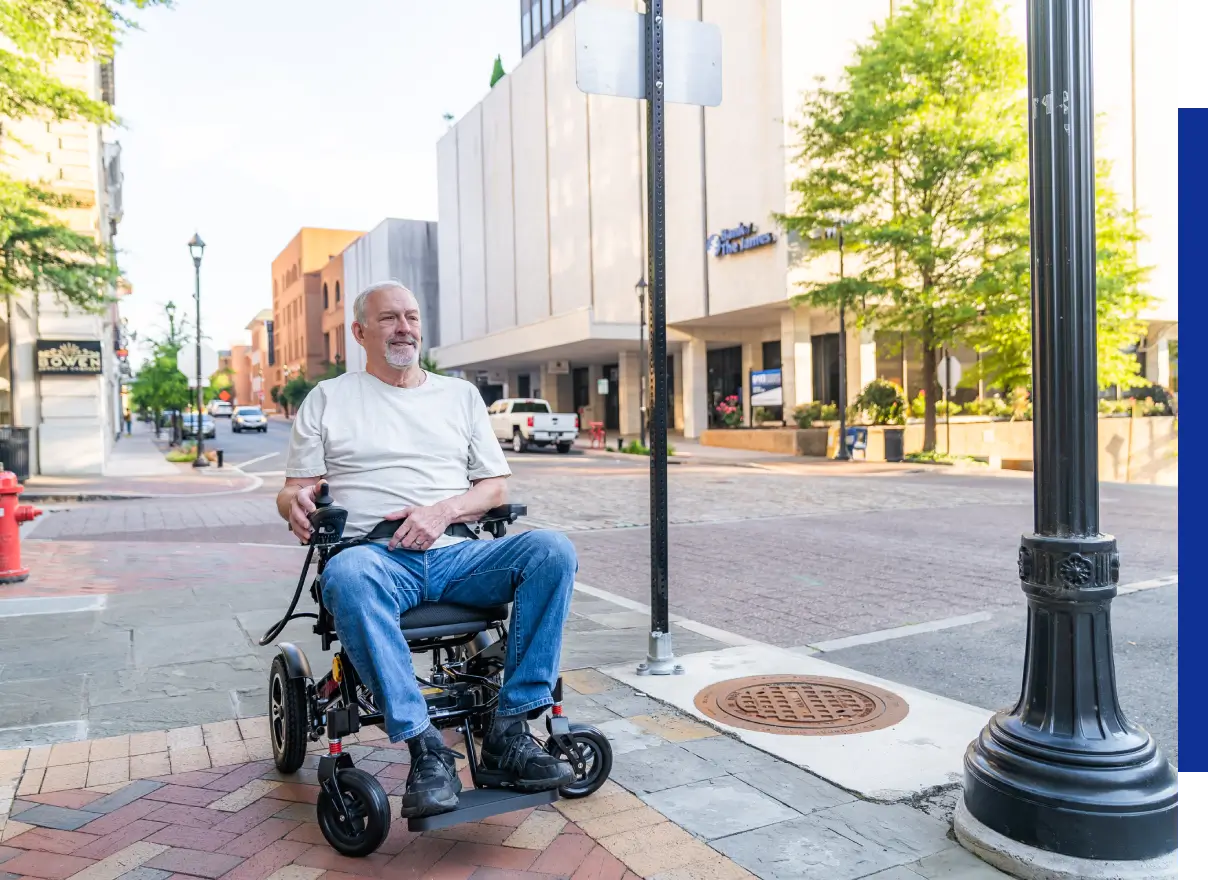 Man in electric wheelchair on city sidewalk