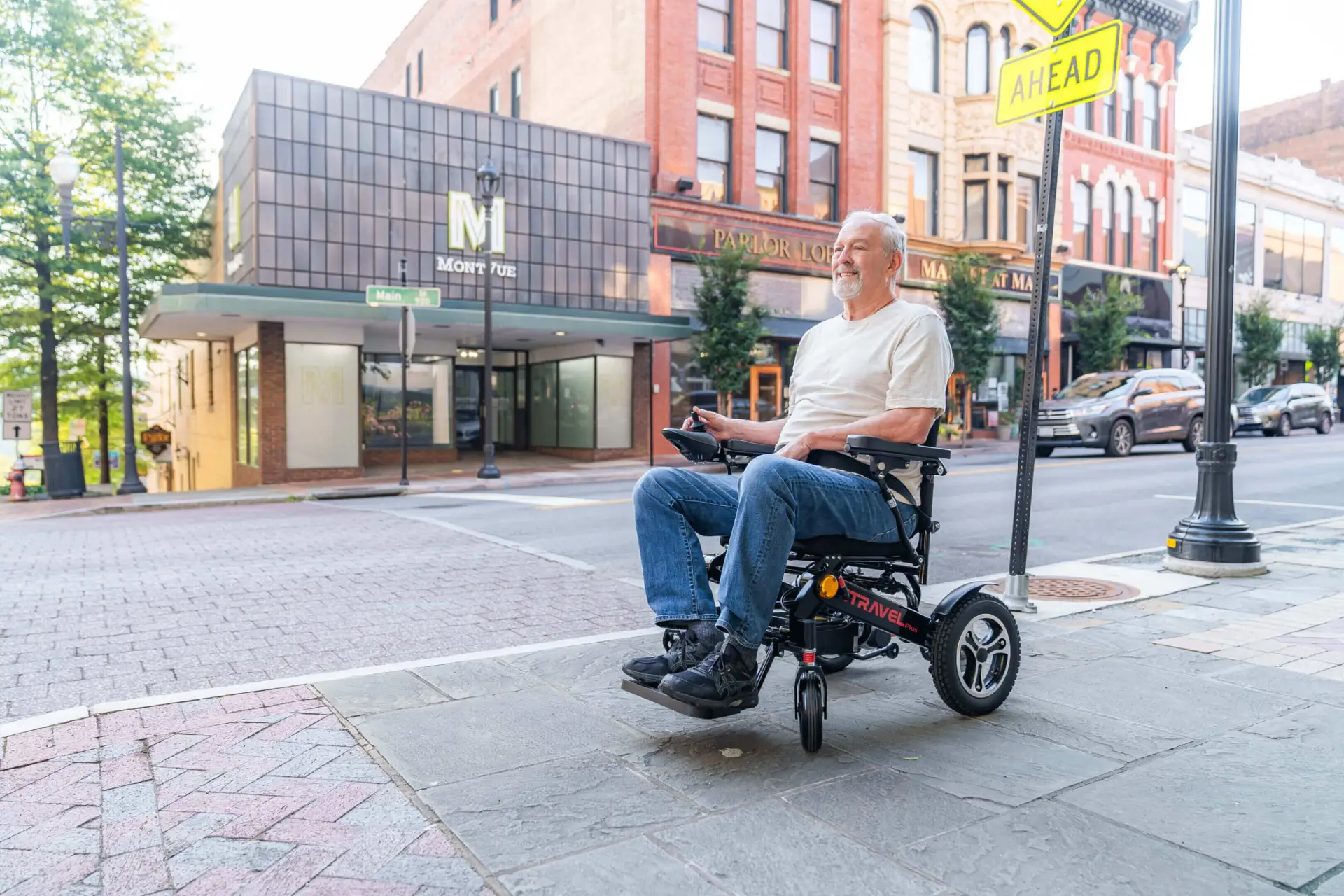 Smiling elderly man in electric wheelchair on sidewalk